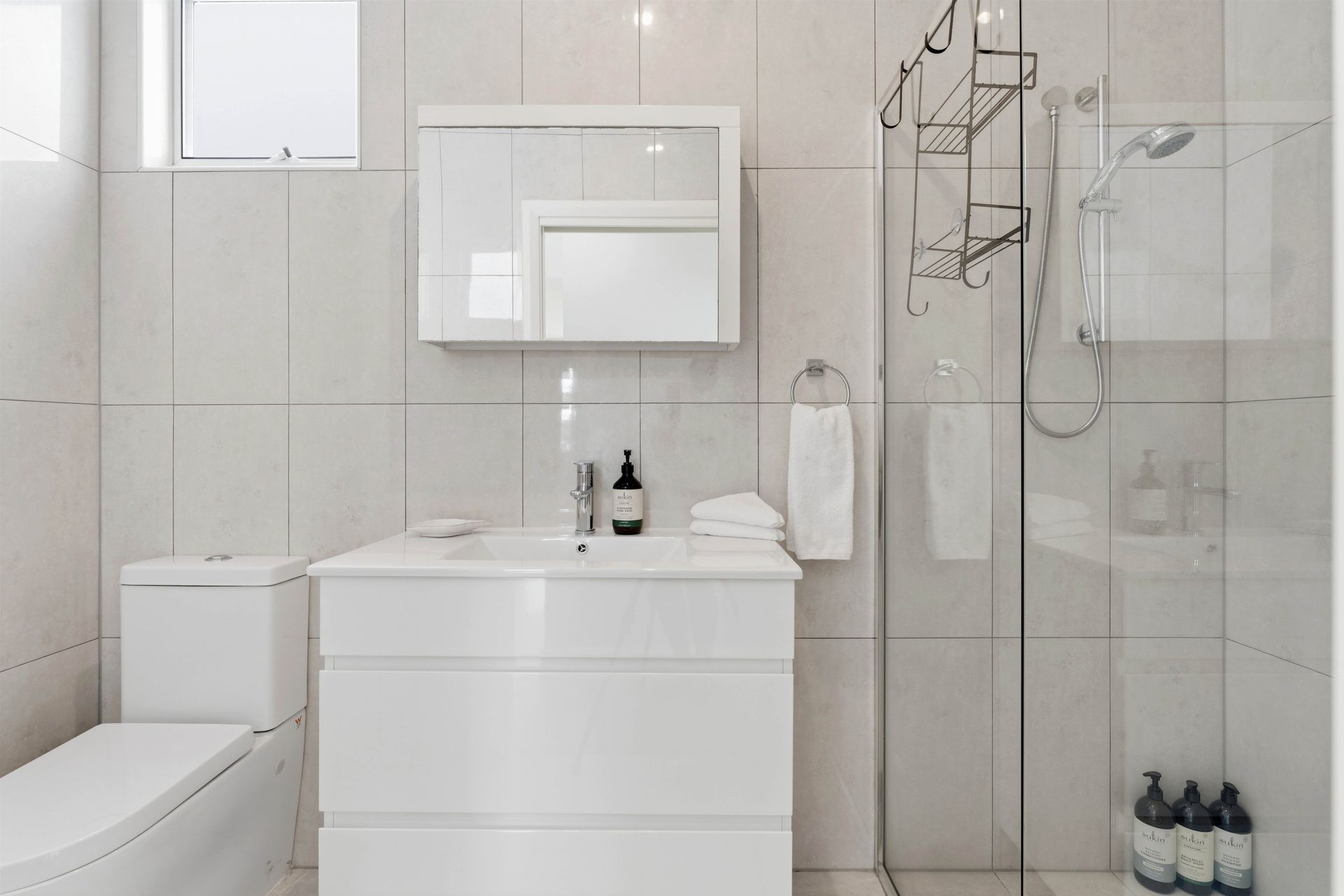 Compact bathroom with shower, vanity and hanging towel rail