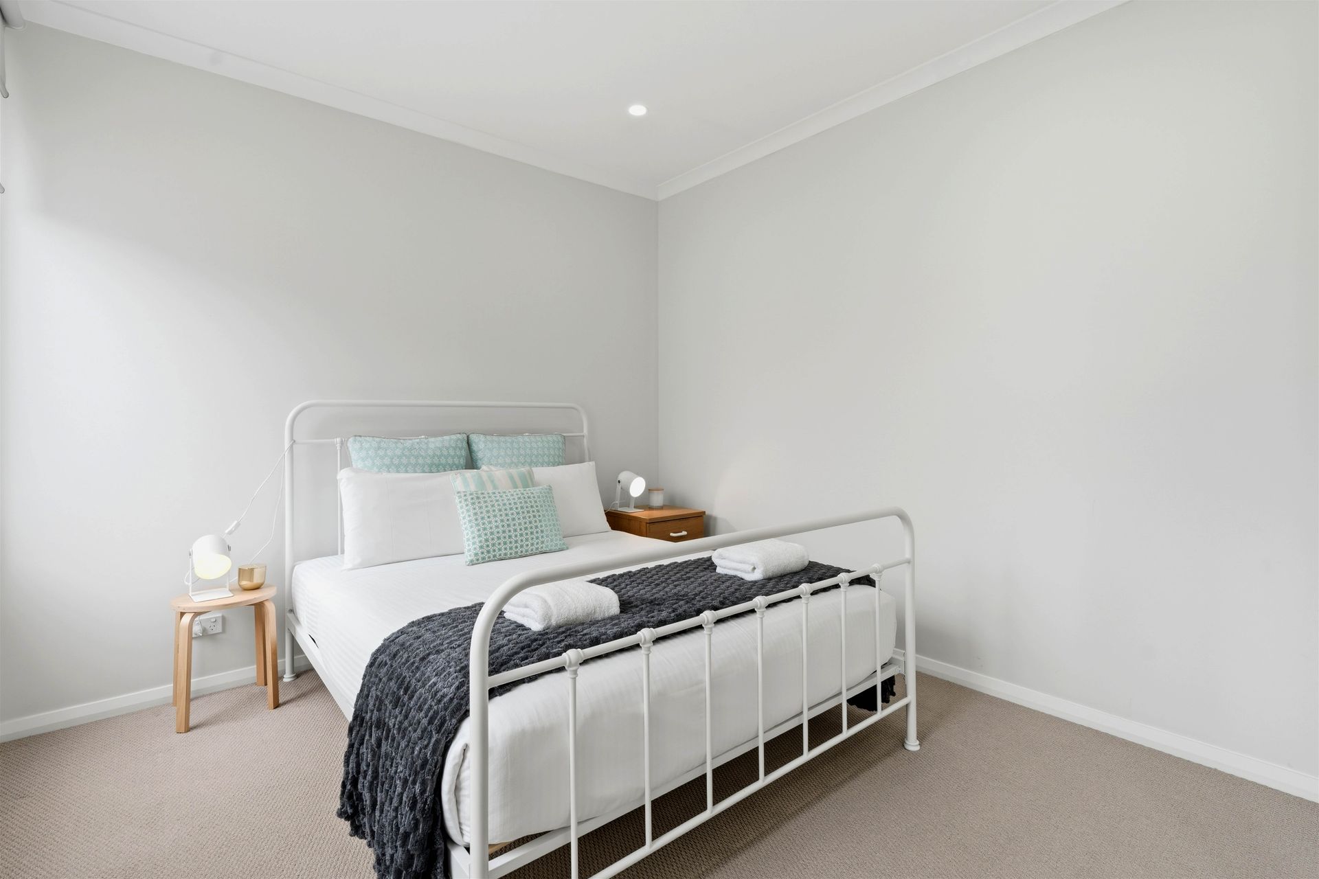 Queen bedroom with bedside table and soft natural light