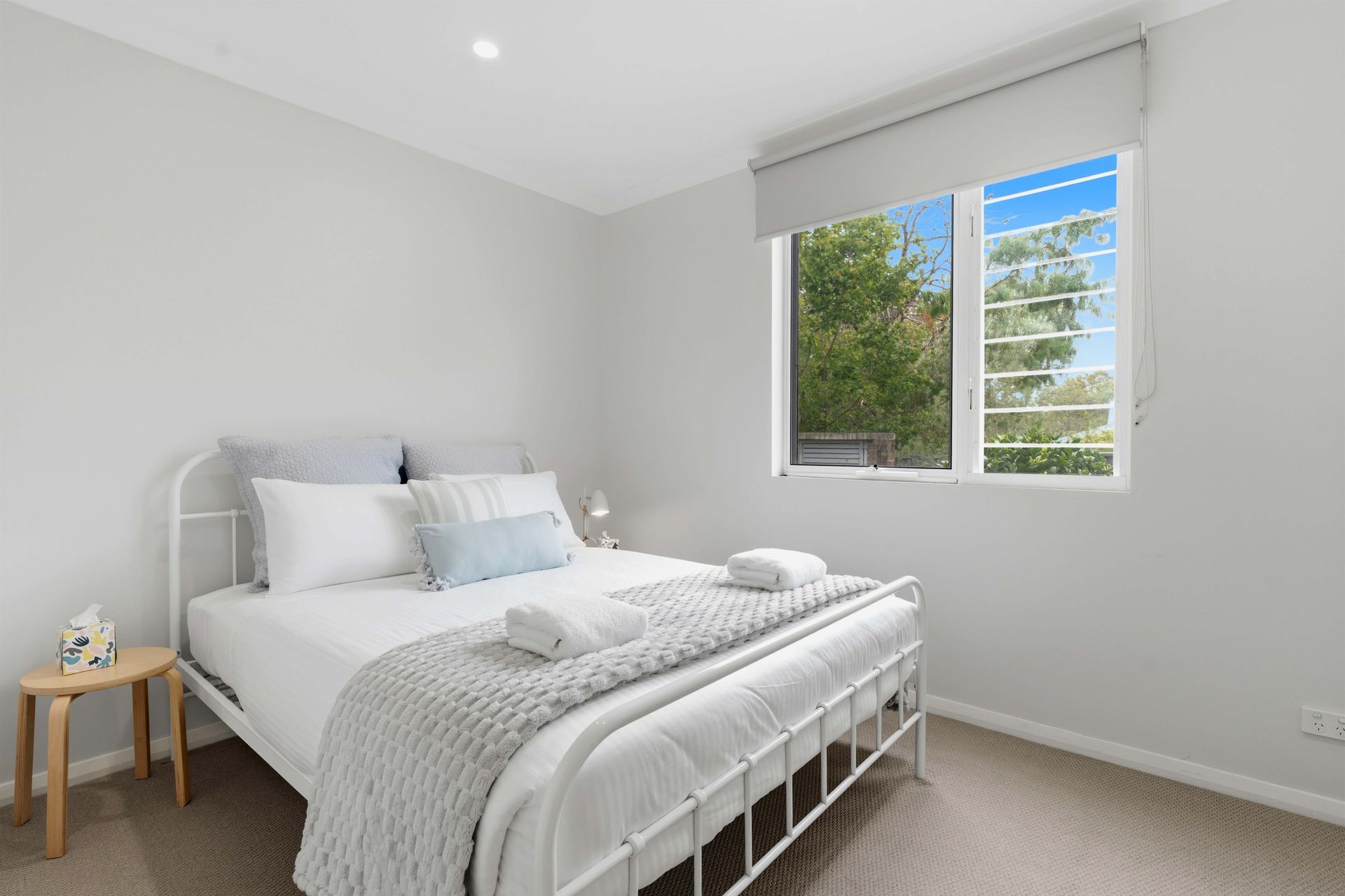 Queen bedroom made up with fresh linen and folded towels
